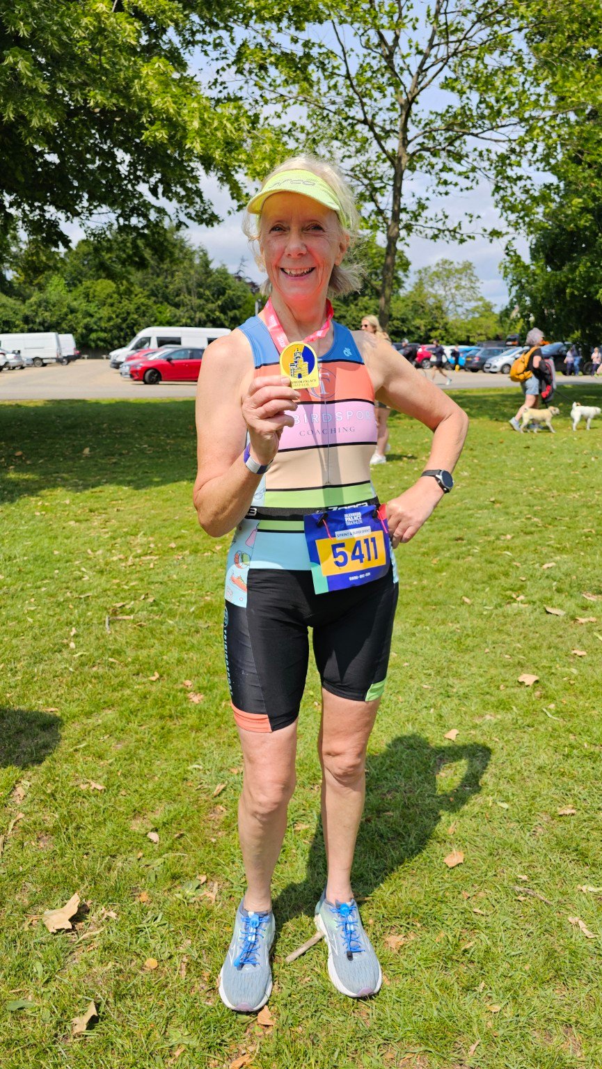 Tina, a Tribirdsport athlete, in Tribirdsport kit and a visor holding her medal